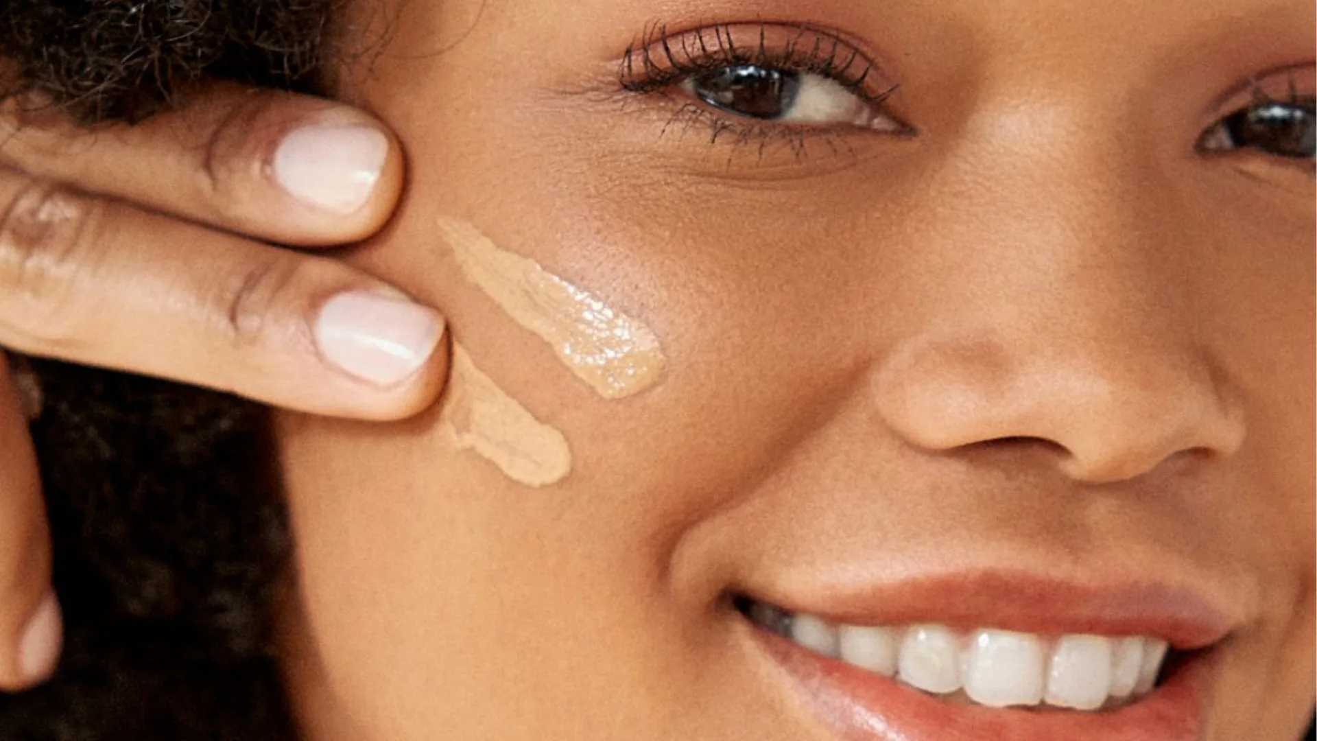 Mulher aplicando protetor solar com cor no rosto para ajudar no controle do melasma.